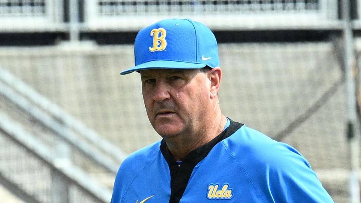  Jun 17, 2025; Omaha, Neb, USA; UCLA Bruins head coach John Savage (22) walks to the dugout before the restart of the game against the LSU Tigers at Charles Schwab Field. Mandatory Credit: Steven Branscombe-Imagn Images | Steven Branscombe-Imagn Images 