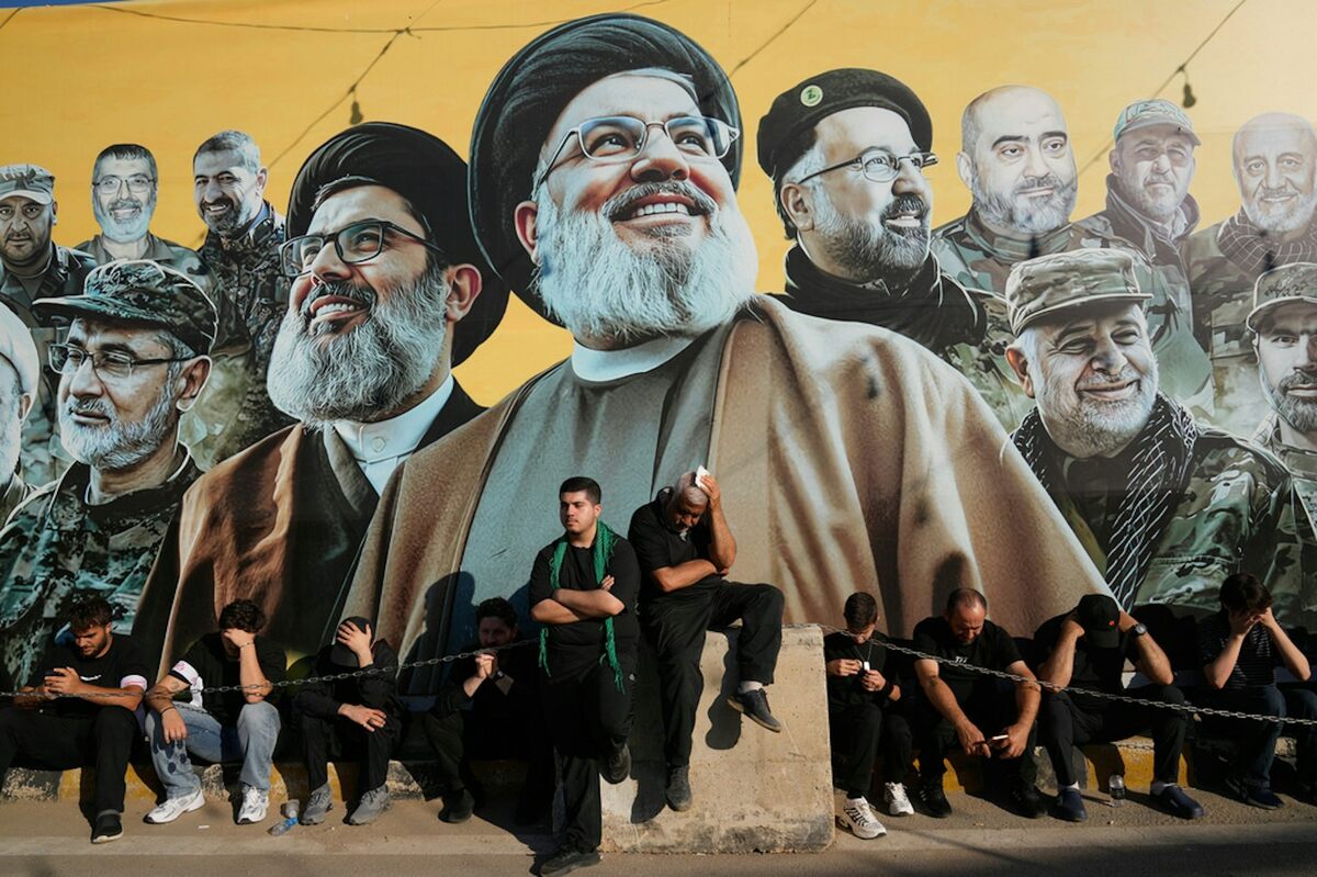  Hezbollah supporters sit in front of a giant billboard that shows the two late Hezbollah leaders – Sayyed Hassan Nasrallah and Hashem Safieddine – with other deceased commanders of the group. AP Photo/Hussein Malla 