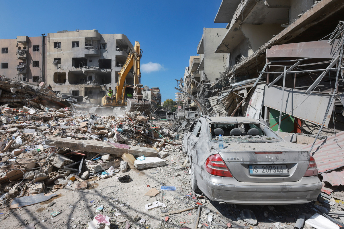 People sit on an excavator as they inspect the damage in the aftermath of an Israeli strike that hit near a hospital on Monday, in Tyre, Lebanon, June 2, 2026. REUTERS/Aziz Taher