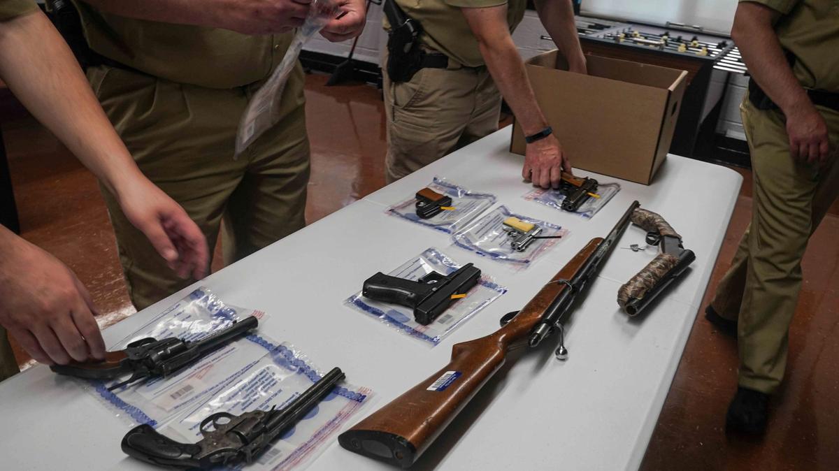 Agentes del Departamento de Policía de Nueva York empacan armas que compraron durante el programa de compra de armas ilegales de la ciudad, el 22 de mayo de 2021 en Brooklin, Nueva York. 