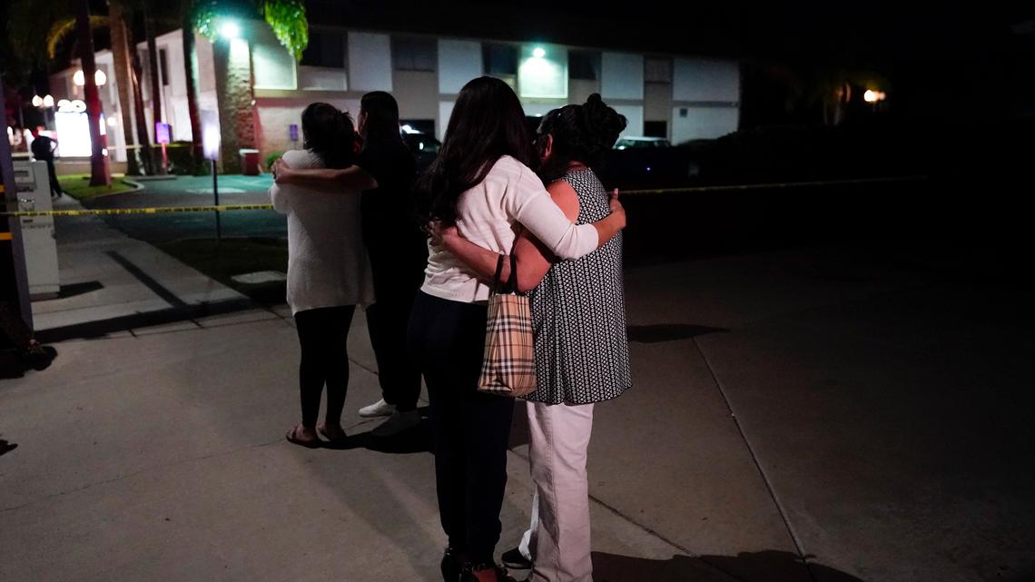 Unidentified people comfort each other as they stand near a business building where a shooting occurred in Orange, Calif., Wednesday, March 31, 2021. Police say several people were killed, including a child, and the suspected shooter was wounded by police. (AP Photo/Jae C. Hong)