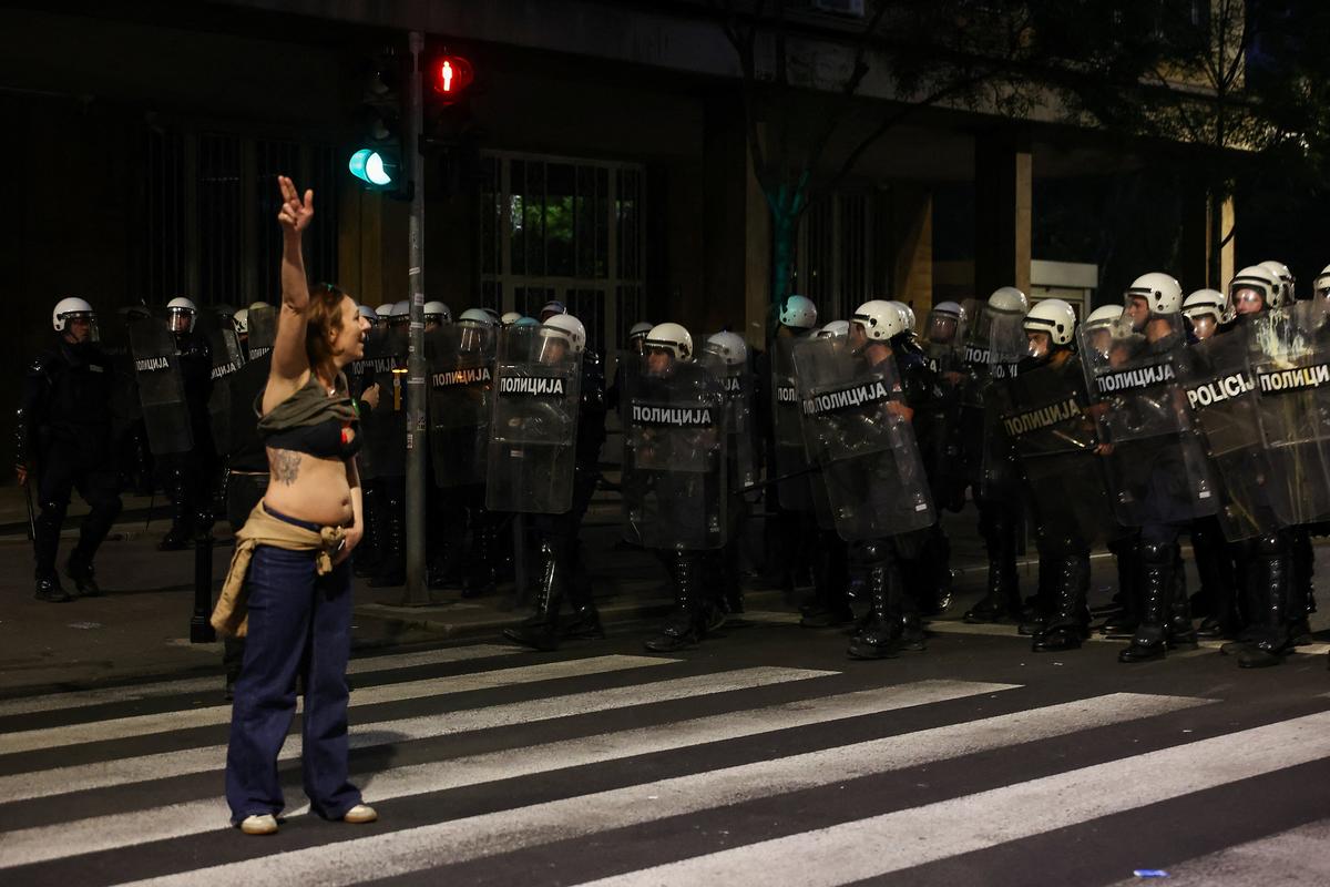 A demonstrator gestures by riot police, during a student-led protest demanding snap parliamentary elections, as Serbia's anti-corruption movement enters a new phase, following the Novi Sad railway station canopy collapse that killed 16 people in 2024, in Belgrade, Serbia, May 23, 2026. REUTERS/Zorana Jevtic