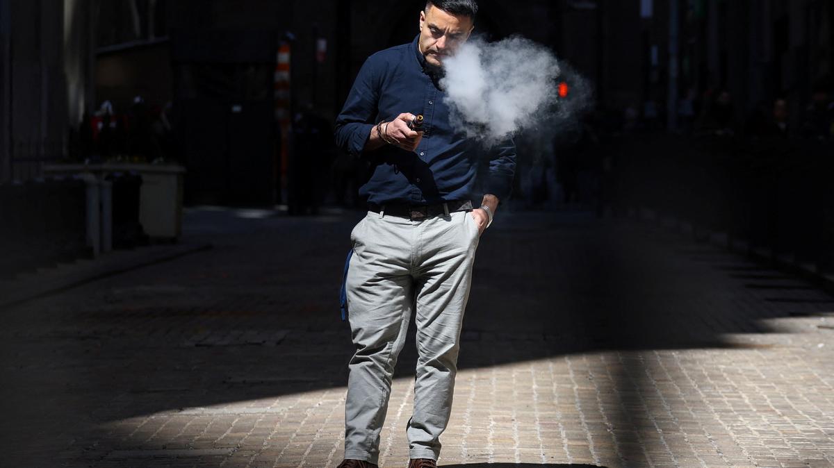 A man uses an e-cigarette on Wall Street outside the New York Stock Exchange (NYSE) in New York City, U.S., April 9, 2025. REUTERS/Kylie Cooper