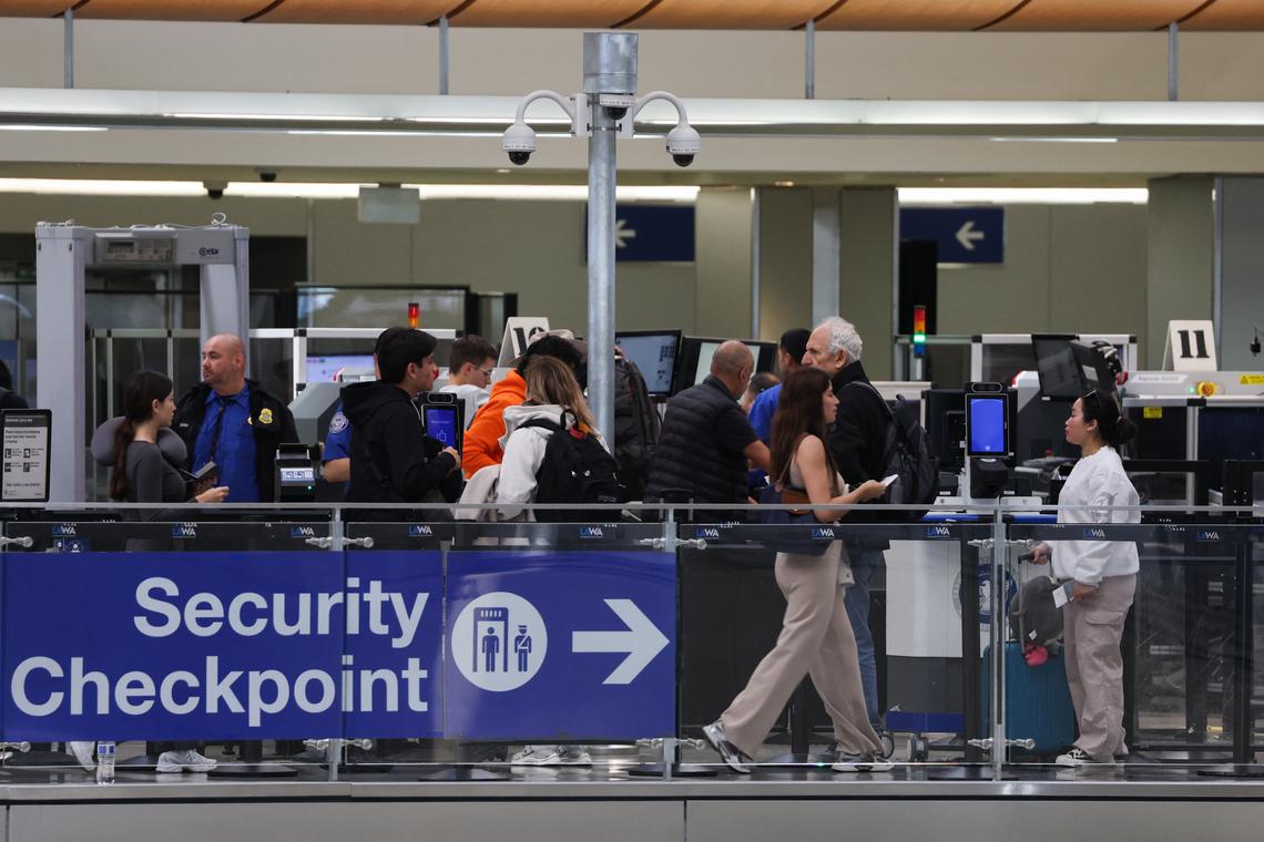  TSA agents screen passengers at a Transportation Security Administration checkpoint inside the Tom Bradley International Terminal at Los Angeles International Airport on March 23, 2026. 