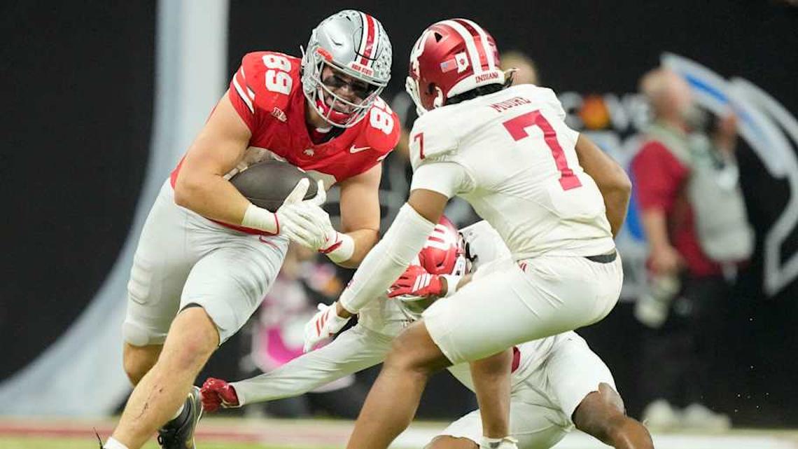  Ohio State Buckeyes tight end Will Kacmarek (89) rushes the ball along the sideline as Indiana Hoosiers defensive back Louis Moore (7) moves in Saturday, Dec. 6, 2025, during the Big Ten football championship at Lucas Oil Stadium in Indianapolis. | Grace Hollars/IndyStar / USA TODAY NETWORK via Imagn Images 