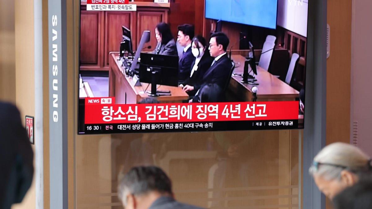 People at Seoul Station watch a live broadcast of a sentencing hearing for former first lady Kim Keon Hee on Tuesday. An appeals court increased Kim's sentence to four years in prison on corruption charges. Photo by Yonhap