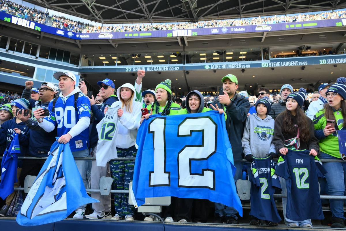  Seattle Seahawks fans hold up a flag before the Super Bowl LX trophy presentation at Lumen Field. Steven Bisig-Imagn Images