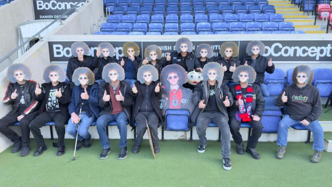 The group wearing Steve McVeighty - known as Raz- masks. (Martin Brunnschweiler via SWNS). 