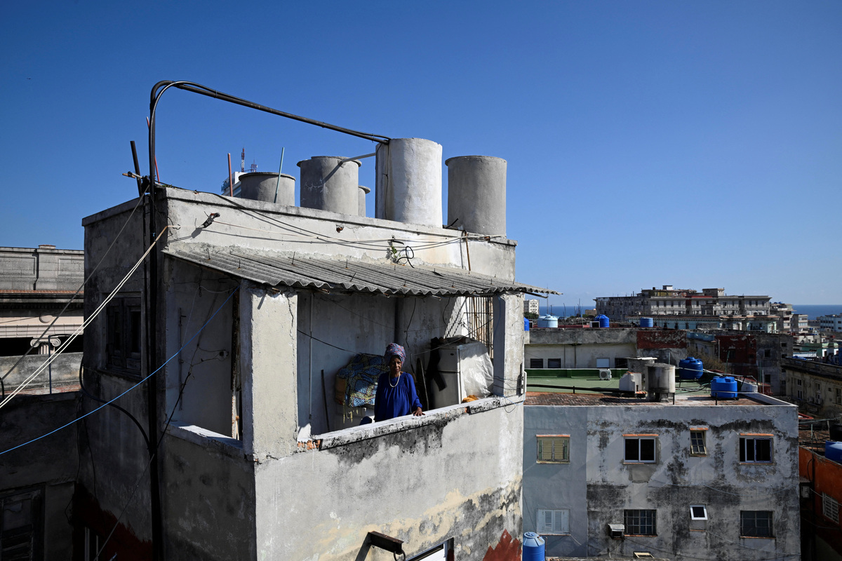 Regina Zaida Jorge, 74, a pensioner, stands on the balcony of her apartment in Havana, Cuba, April 29, 2026. Jorge lives alone and relies on church groups for food. Cuba, the fastest-aging nation in Latin America and the Caribbean, has struggled for years under U.S. sanctions to provide basic services, with seniors now facing harsher conditions after a Trump administration move to cut off the island's fuel supply. REUTERS/Norlys Perez
