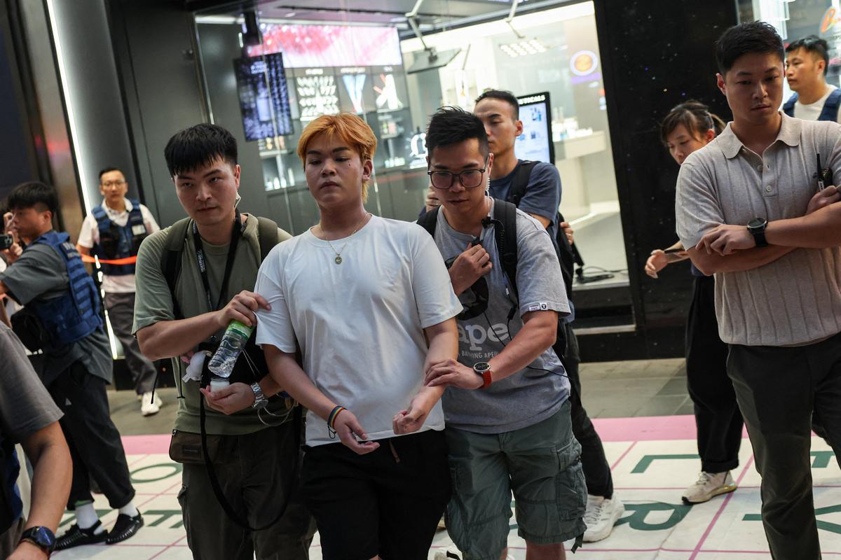 Plainclothes police detain a man holding a candle near Victoria Park, the historic site of Tiananmen Square vigils, in Hong Kong, China, June 4, 2026. REUTERS/Tyrone Siu