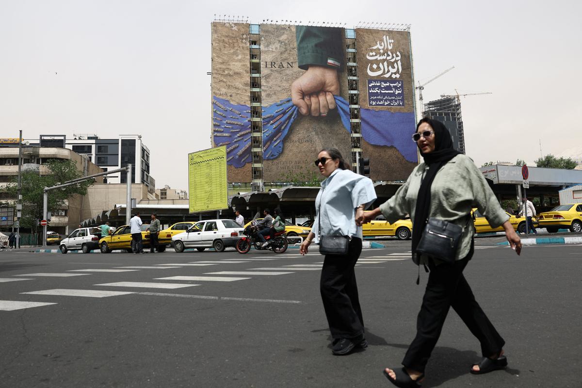 People walk past a billboard with a graphic design about the Strait of Hormuz on a building, in Tehran, Iran, May 4, 2026. Majid Asgaripour/WANA (West Asia News Agency) via REUTERS