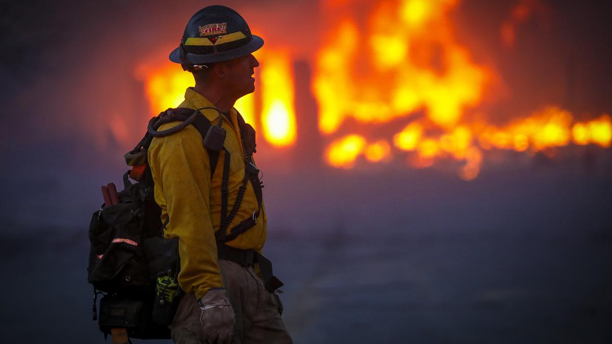 A Mountain View wildland firefighter walks through the smoke and haze after a fast-moving wildfire swept through the area in the Centennial Heights neighborhood of Louisville, Colorado, on Dec. 30, 2021. State officials estimated some 600 homes had already been lost in multiple areas around Boulder County and were fueled by winds that gusted upwards of 100 miles per hour at times during the day. (Marc Piscotty/Getty Images/TNS)