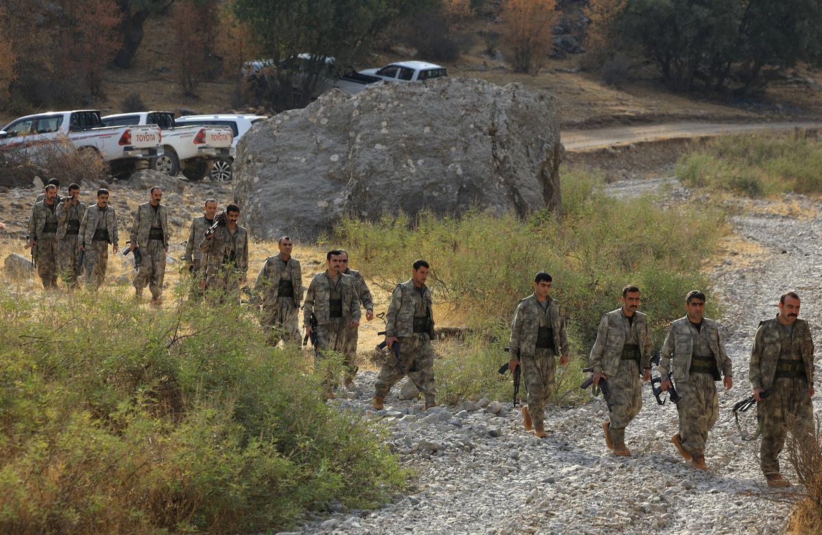 FILE PHOTO: Fighters with the Kurdistan Workers' Party (PKK) walk for a disarmament ceremony marking a significant step toward ending the decades-long conflict between Turkey and the outlawed group in the Qandil mountains, Iraq October 26, 2025. REUTERS/Thaier Al-Sudani/File Photo