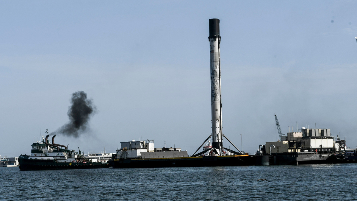 Spectators watch as a SpaceX first-stage booster that launched a GPS III satellite is brought into Port Canaveral on July 4, 2020, aboard the drone ship Just Read the Instructions.