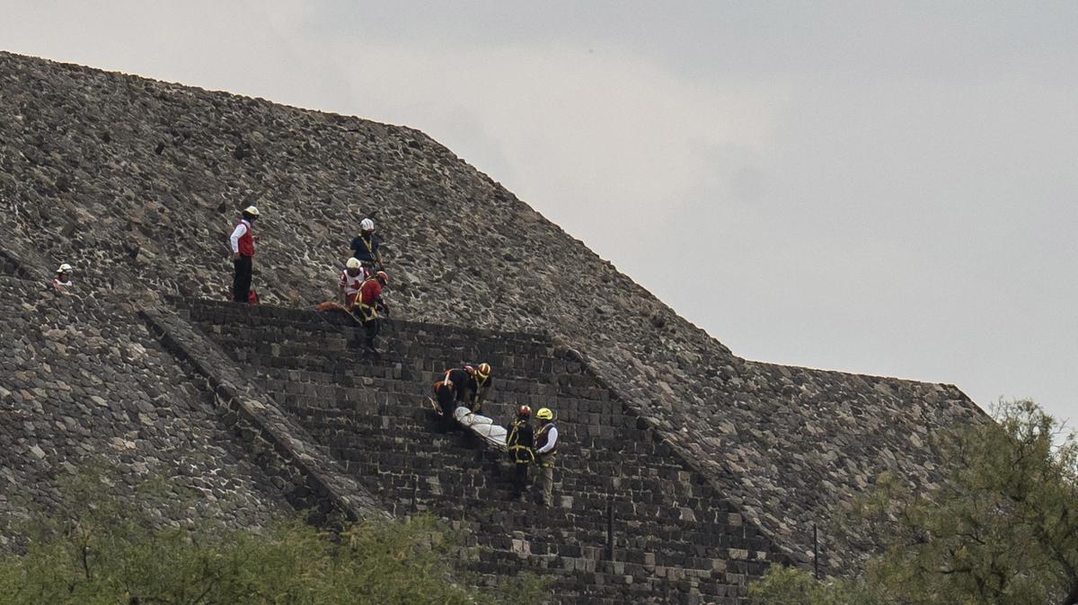 Red Cross personnel descend from the Pyramid of the Moon carrying the body while forensic investigators search the area after a shooting that killed one tourist on Monday, April 20, 2026 in Teotihuacan, Mexico. (Cristopher Rogel Blanquet/Getty Images/TNS)
