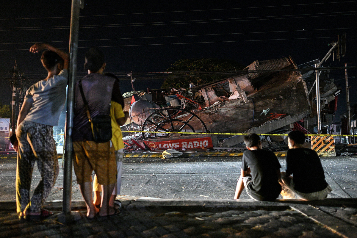 People look at a collapsed building following the magnitude 7.8 quake in General Santos, southern Philippines, June 8, 2026. REUTERS/Noel Celis