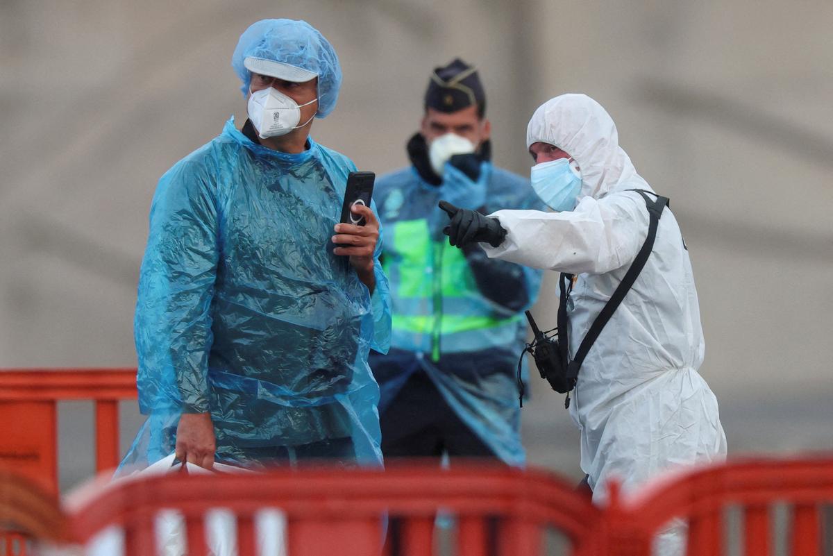 A U.S. passenger from the cruise ship MV Hondius, affected by a hantavirus outbreak, is instructed by personnel after disembarking a boat, at the port of Granadilla de Abona, in Tenerife, Spain, May 10, 2026. REUTERS/Hannah McKay