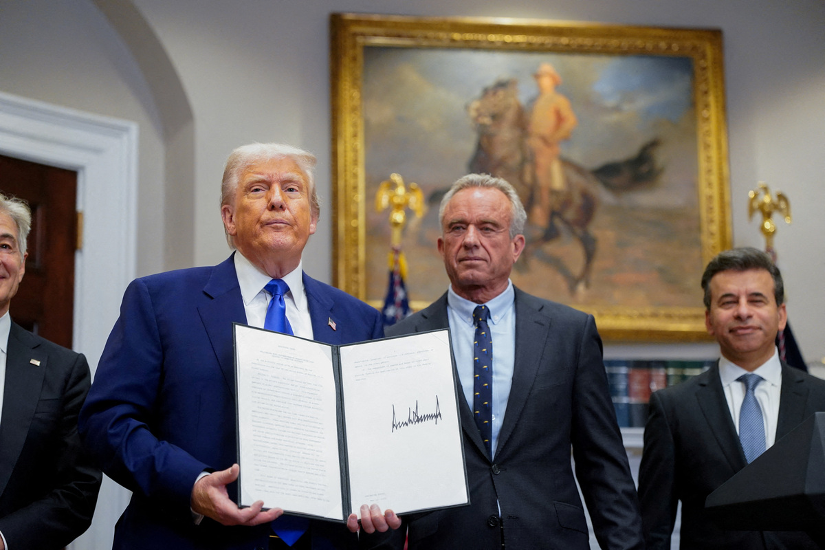 FILE PHOTO: U.S. President Donald Trump holds an executive order on prescription drug pricing next to U.S. Health and Human Services (HHS) Secretary Robert F. Kennedy, Jr., during a press conference in the Roosevelt Room at the White House in Washington, D.C., U.S., May 12, 2025. REUTERS/Nathan Howard/File Photo