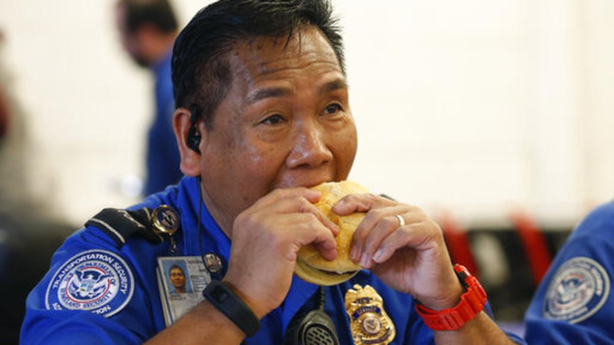 Un empleado de la Administración de Seguridad en el Transporte (TSA) almuerza una hamburguesa en el Aeropuerto Internacional de Salt Lake City, Utah, el 16 de enero de 2019.