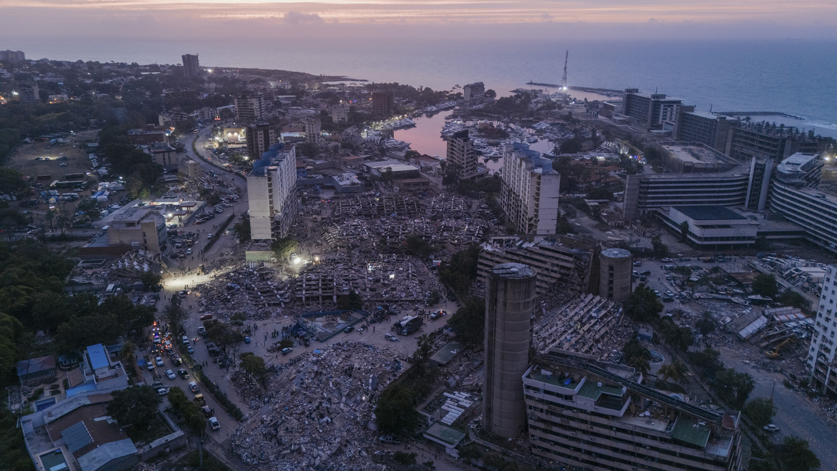 Rescuers work at dusk amid a group of collapsed residential buildings in La Guaira, Venezuela, June 30, 2026. After devastating twin earthquakes flattened entire residential neighborhoods last week, experts fear the official death toll of 1,719 could be a serious undercount. (Adriana Loureiro Fernandez/The New York Times)