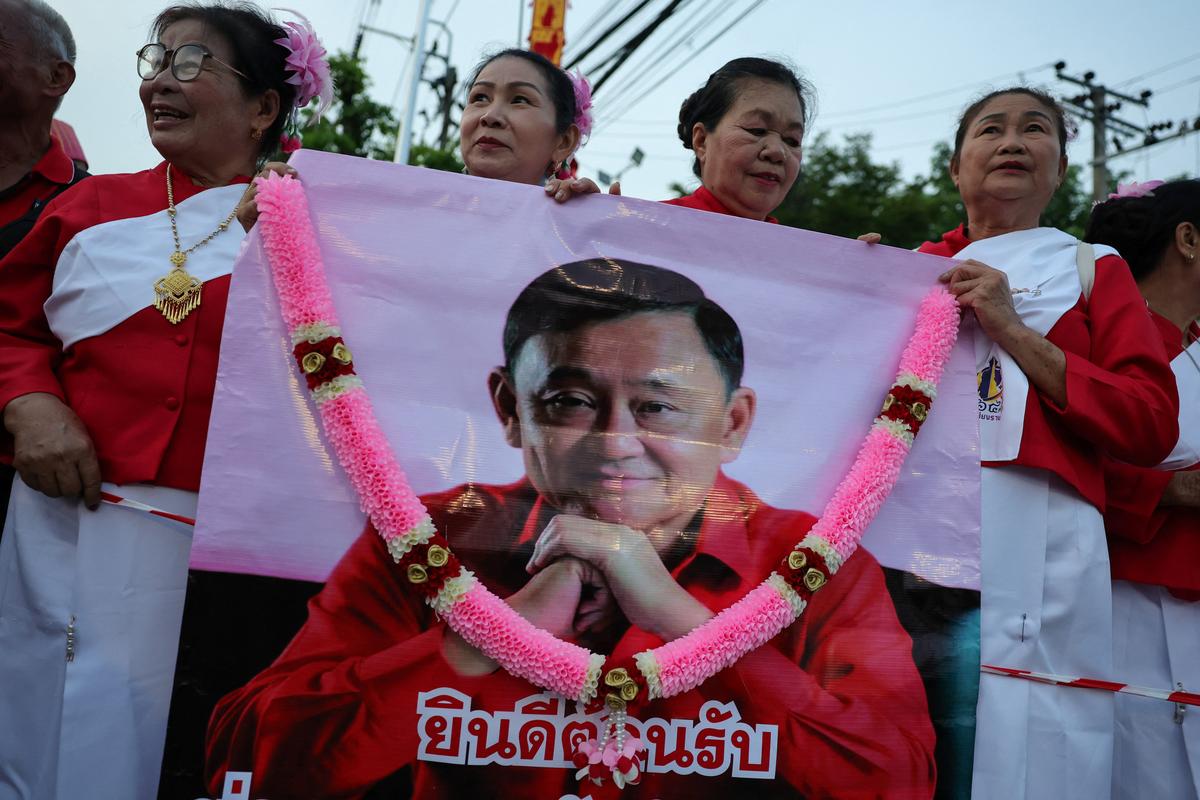 Supporters of former Thai Prime Minister Thaksin Shinawatra wait for his release on parole after serving eight months of his one-year sentence at Klong Prem Central Prison, in Bangkok, Thailand, May 11, 2026. REUTERS/Athit Perawongmetha