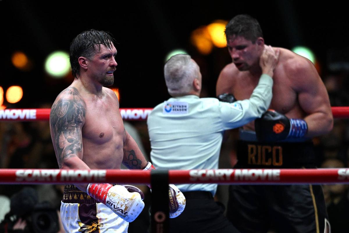  Oleksandr Usyk (L) stands in the boxing ring as the referee (center) speaks to Rico Verhoeven (R) as their match comes to an end in Giza, Egypt. Mohamed Hossam/Getty Images