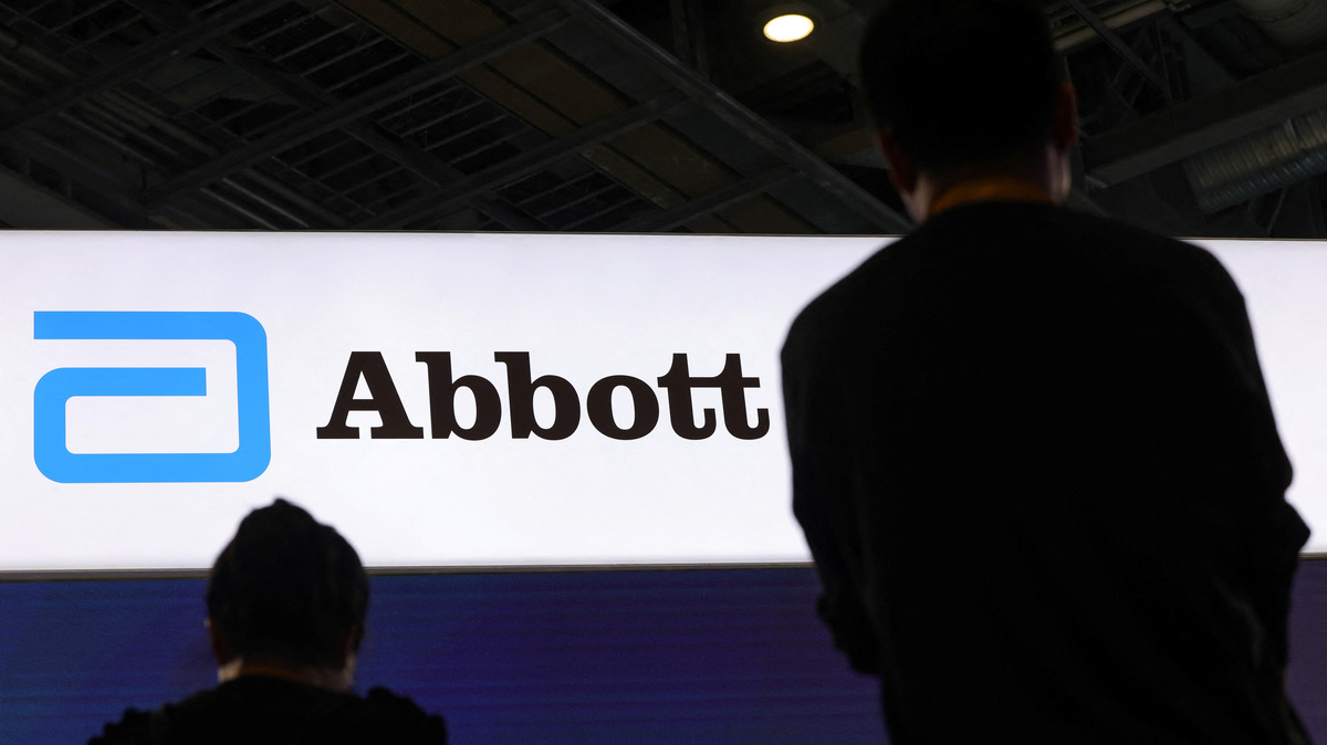 People stand next to a logo of Abbott at the company’s booth at the 8th China International Import Expo (CIIE) in Shanghai, China, November 6, 2025.REUTERS/Maxim Shemetov