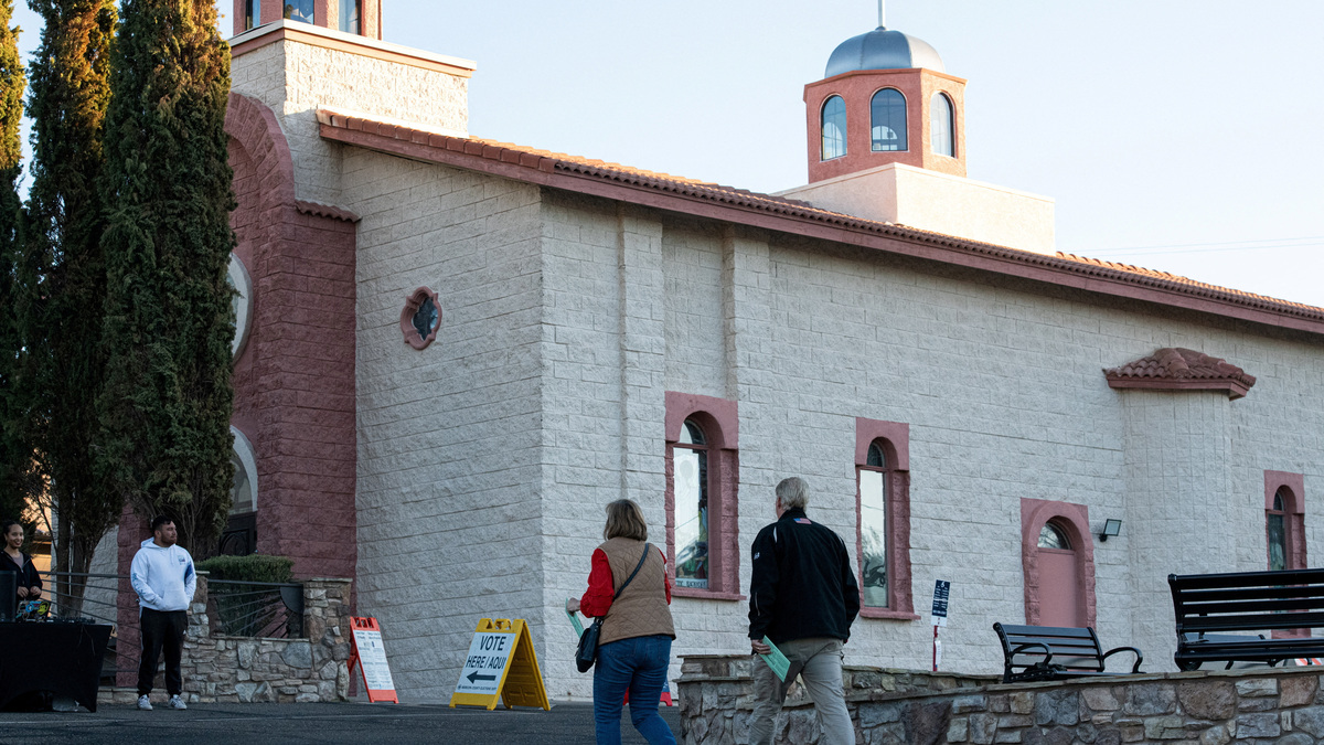 FILE PHOTO: A man and woman walk into a voting center with their mail-in ballots at St. Nikolas Serbian Church, on Election Day, in Phoenix, Arizona, U.S., November 5, 2024.  REUTERS/Caitlin O'Hara/File Photo