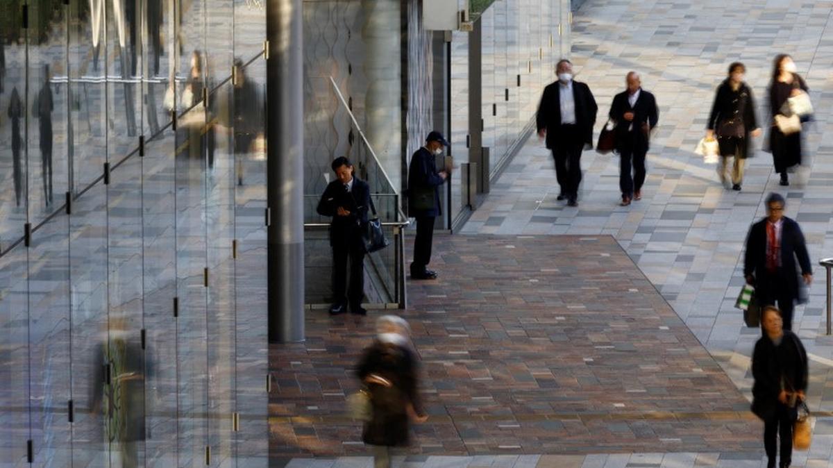 A man uses a laptop on a street at a business district in Tokyo, Japan January 23, 2024. REUTERS/Kim Kyung-Hoon