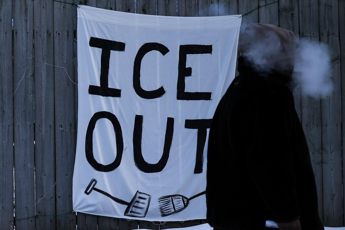  A man walks past an anti-ICE sign hanging on a fence in Minneapolis, Minnesota, on February 3, 2026. 