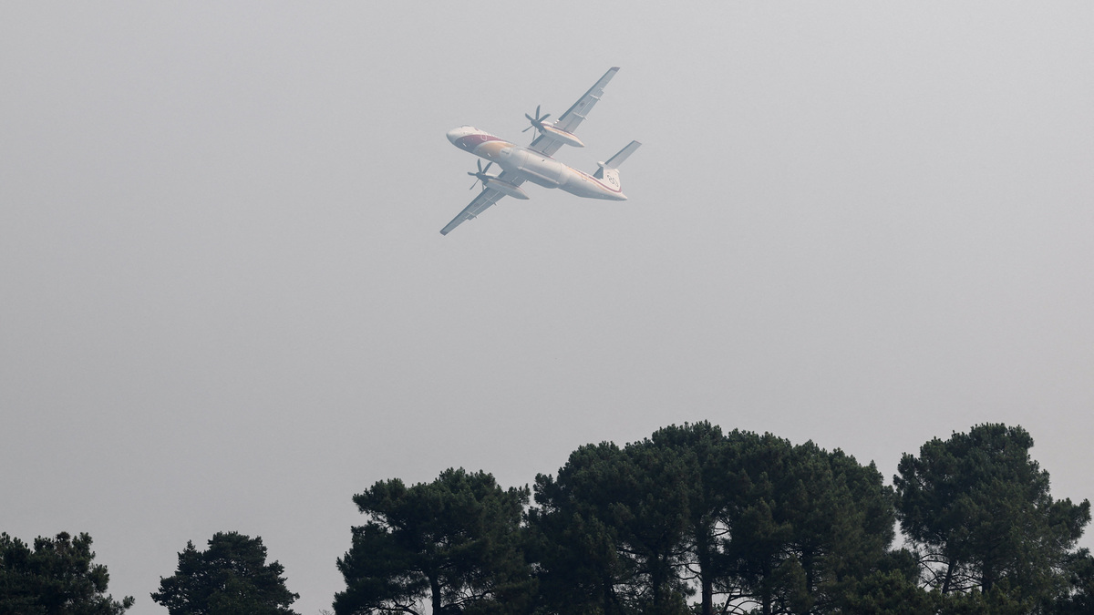 Aerial firefighting plane, De Havilland Canada Dash 8-402 MR, flies as French firefighters battle a wildfire in the Fontainebleau forest in in Noisy-sur-Ecole near Paris, amid a heatwave affecting a large part of the country, France, July 13, 2026. REUTERS/Benoit Tessier