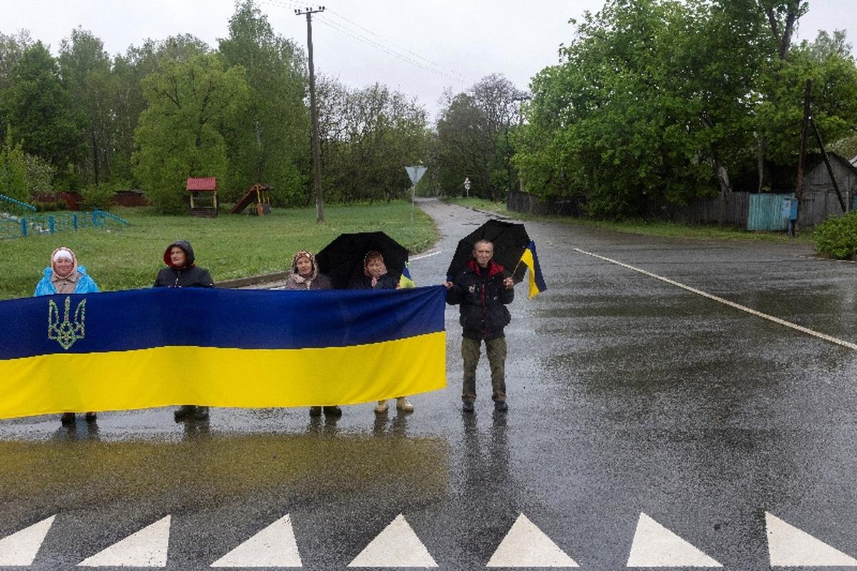 Locals wait to greet Ukrainian servicemen and former prisoners of war (POW) after a POW swap with Russia, amid Russia's attack on Ukraine, at an undisclosed location in Ukraine May 15, 2026. REUTERS/Thomas Peter