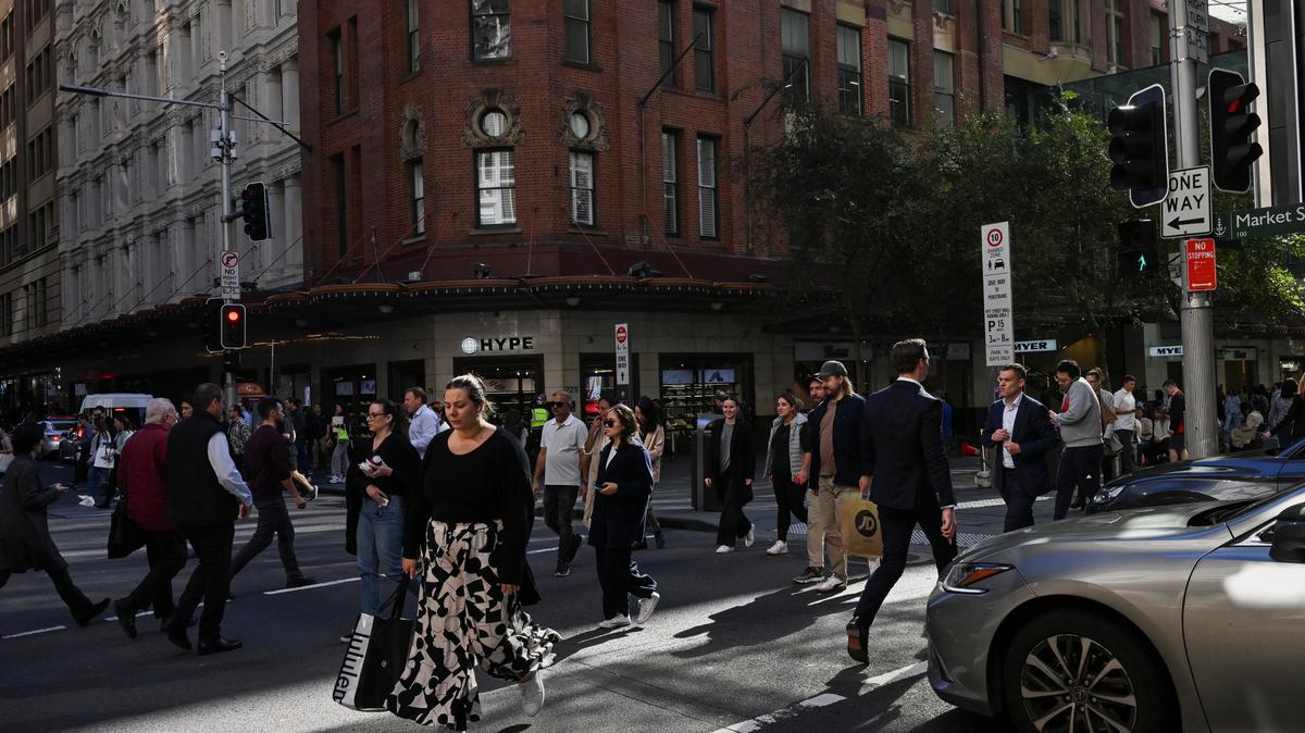 People cross the street in the Sydney Central Business District, in Sydney, Australia, May 14, 2024. REUTERS/Jaimi Joy