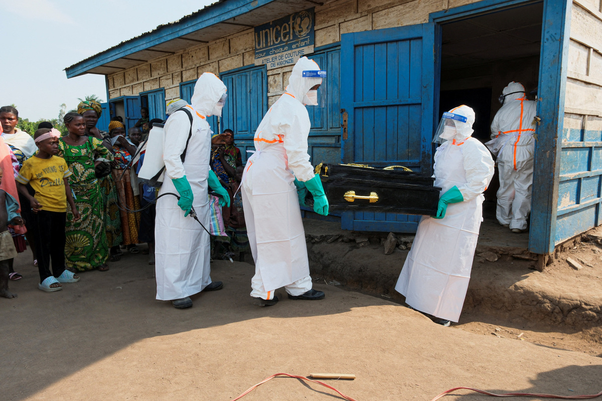 Health workers wearing personal protective equipment (PPE) carry the coffin of a child who is suspected to have died of Ebola for burial at the Kigonze displaced persons camp, one month after an Ebola outbreak was declared, in Bunia, eastern Democratic Republic of Congo, June 18, 2026. REUTERS/Gradel Muyisa Mumbere
