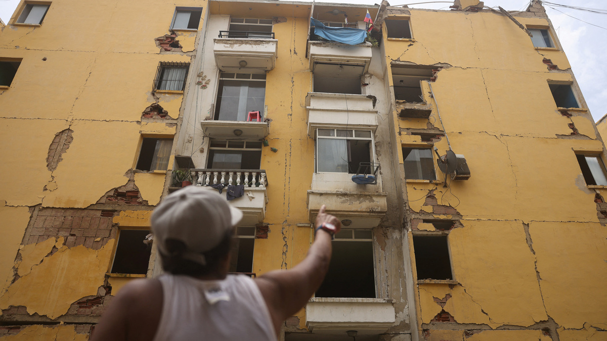 Maru Nunez, 59, points at a damaged housing building at Mision Vivienda, which was affected by the June 24 earthquakes, in Catia La Mar, La Guaira State, Venezuela, July 12, 2026. REUTERS/Leonardo Fernandez Viloria