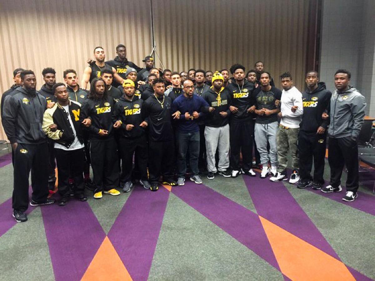Activist Jonathan Butler, center, is surrounded in solidarity by a group of Black football players on Nov. 7, 2015. "The football team's actions were the equivalent of throwing gasoline on a small fire," then-University of Missouri System President Tim Wolfe wrote in an email to university supporters.