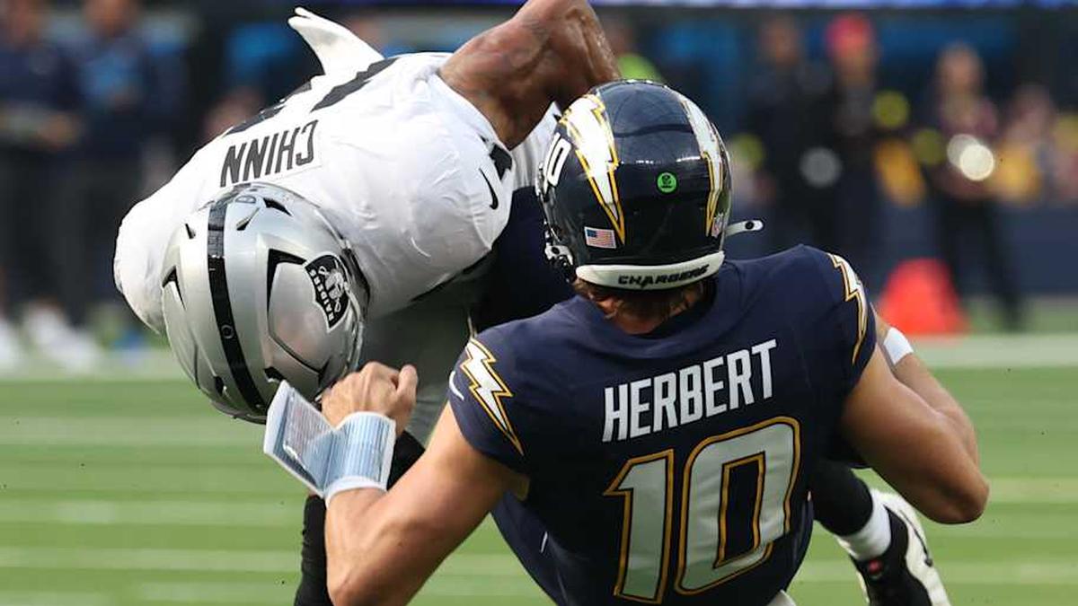  Nov 30, 2025; Inglewood, California, USA; Las Vegas Raiders safety Jeremy Chinn (11) tackles Los Angeles Chargers quarterback Justin Herbert (10) during the first half at SoFi Stadium. Mandatory Credit: Kiyoshi Mio-Imagn Images | Kiyoshi Mio-Imagn Images 