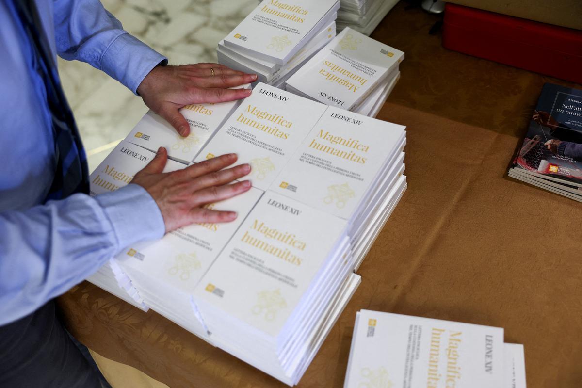 FILE PHOTO: A worker places copies of "Magnifica humanitas", Pope Leo XIV's first encyclical, focused on the rise of artificial intelligence, in front of the Paul VI Hall, following the encyclical's presentation, at the Vatican, May 25, 2026. REUTERS/Yara Nardi/File Photo