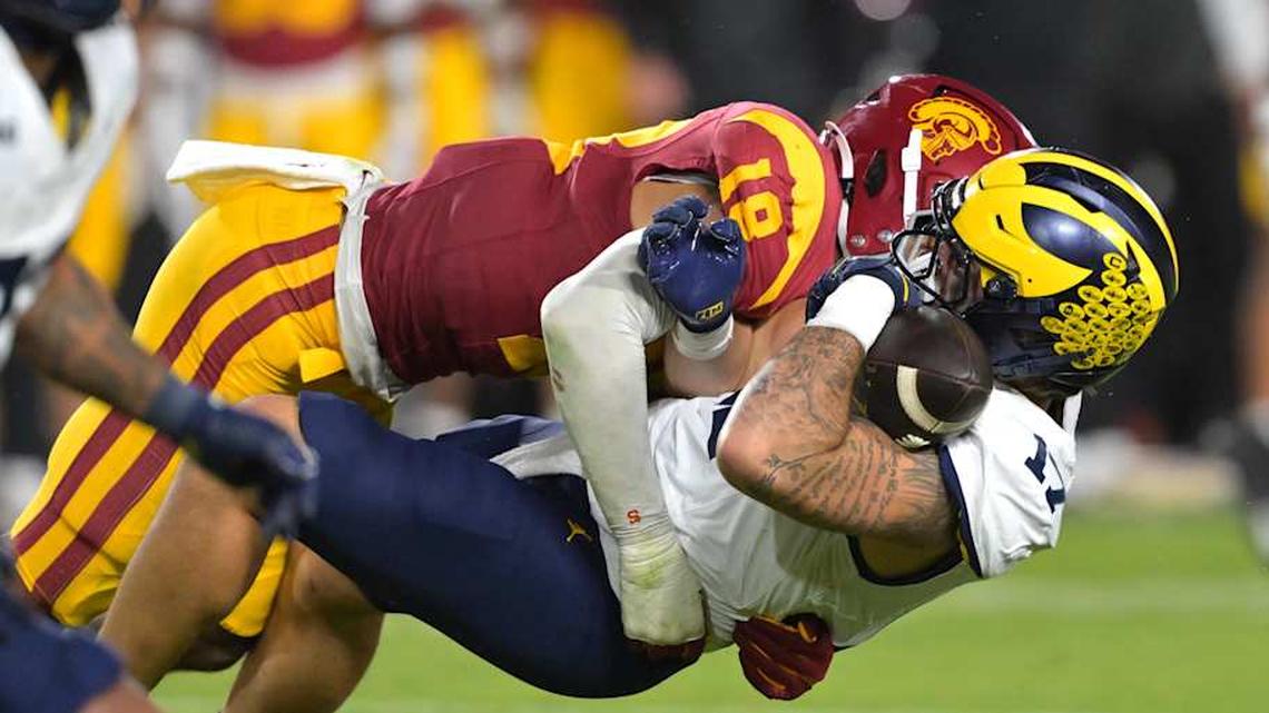  Oct 11, 2025; Los Angeles, California, USA; Michigan Wolverines tight end Marlin Klein (17) hangs on to the ball after a complete pass as he is stopped by USC Trojans linebacker Eric Gentry (18) in the second half at United Airlines Field at the Los Angeles Memorial Coliseum. Mandatory Credit: Jayne Kamin-Oncea-Imagn Images | Jayne Kamin-Oncea-Imagn Images 