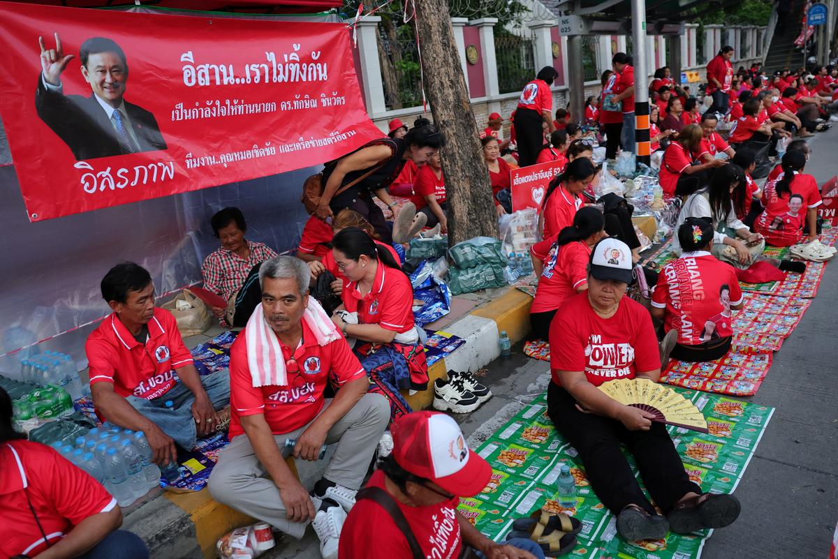 Supporters of former Thai Prime Minister Thaksin Shinawatra wait for his release on parole after serving eight months of his one-year sentence at Klong Prem Central Prison, in Bangkok, Thailand, May 11, 2026. REUTERS/Athit Perawongmetha