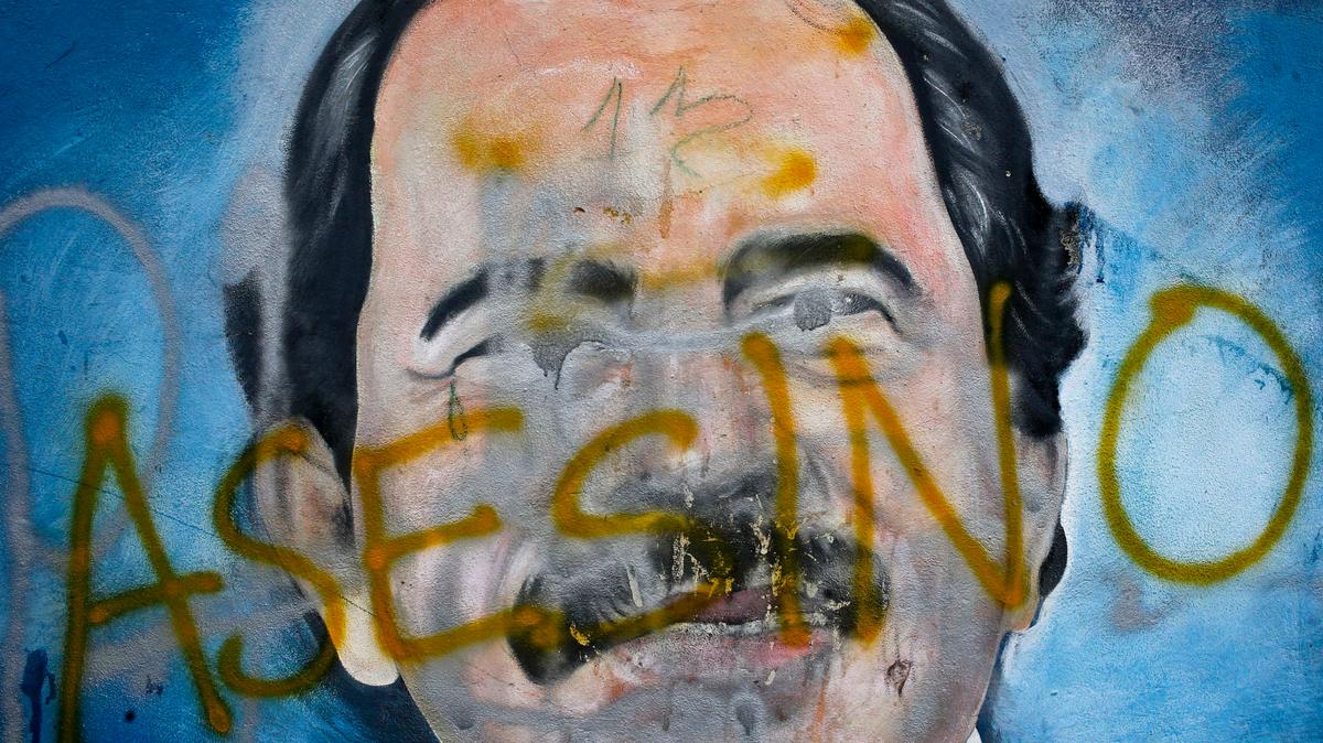 ARCHIVO - La palabra “asesino” fue escrita sobre un mural del presidente nicaragüense Daniel Ortega durante las protestas antigubernamentales en las que le exigían su renuncia, en Managua, el 26 de mayo de 2018. (AP Foto/Esteban Felix, Archivo)