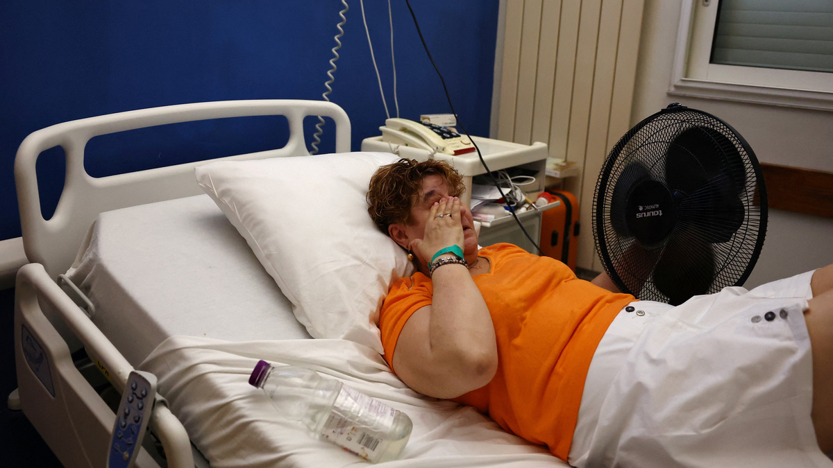 A patient lying in a hospital bed cools off with an electric fan at the Manhes Private Hospital in Fleury-Merogis near Paris during a heatwave affecting a majority of the country, France, June 25, 2026. REUTERS/Abdul Saboor
