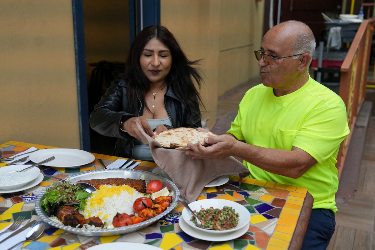 Iranian Saied Assadi, owner of the Comida Persa Iran restaurant, and his Mexican partner Claudia Leonardo eat at the venue in Rosarito, on the outskirts of Tijuana, where a small Iranian community reflects broader political divisions within the diaspora ahead of the team’s World Cup campaign, in Rosarito, Mexico, June 10, 2026. REUTERS/Aimee Melo