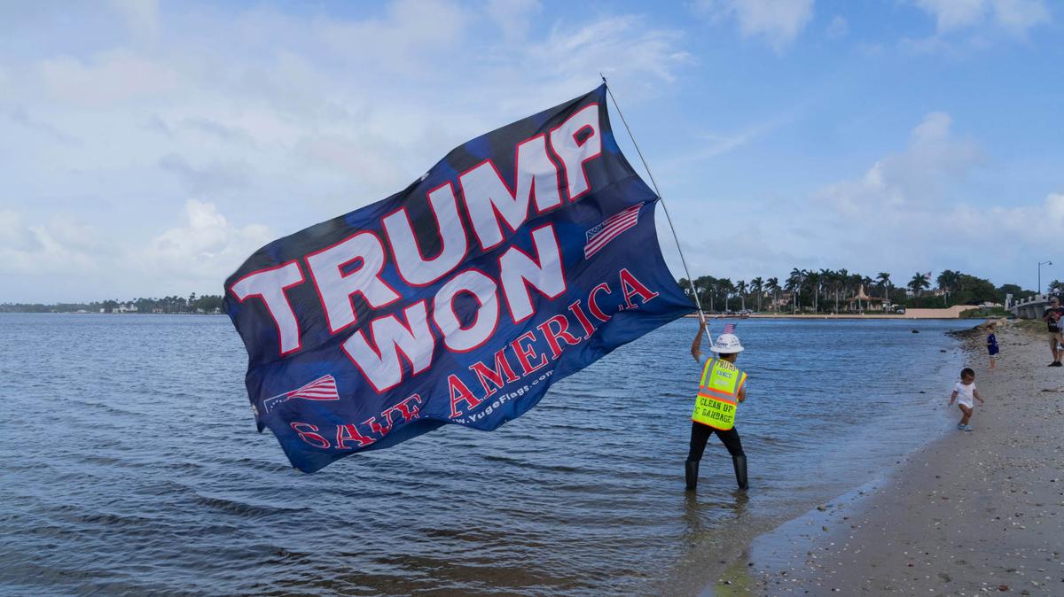 Una persona sostiene una bandera en apoyo al presidente electo Donald Trump en Palm Beach, Florida, el miércoles 6 de noviembre de 2024.