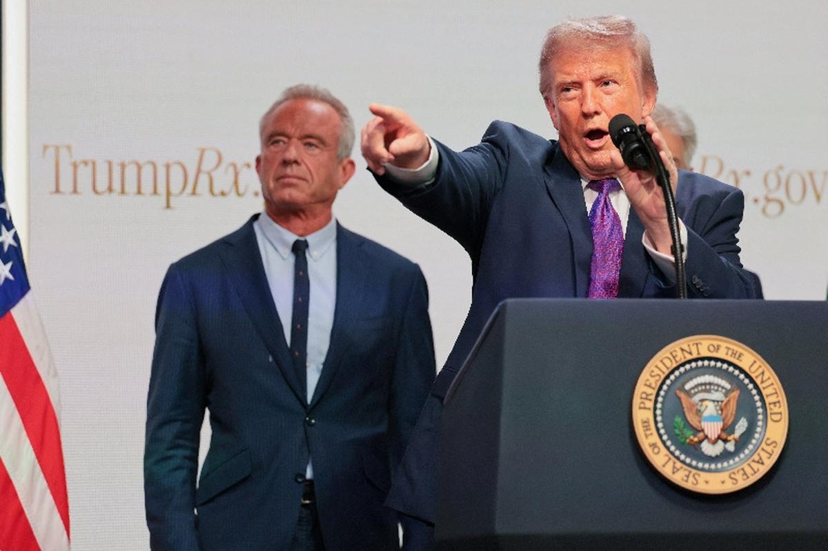 Centre for Medicare & Medicaid Services Administrator Dr Mehmet Oz and U.S. Health and Human Services Secretary Robert F. Kennedy Jr. stand behind U.S. President Donald Trump as he points while delivering remarks about health care costs and affordability from an auditorium on the White House campus in Washington, D.C., U.S., May 18, 2026. REUTERS/Jonathan Ernst