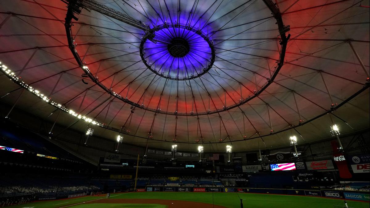 The roof inside Tropicana Field is illuminated red, white, and blue during the playing of the National Anthem before a baseball game between the Tampa Bay Rays and the Boston Red Sox Friday, Sept. 11, 2020, in St. Petersburg, Fla. Today marks the 19th anniversary of the Sept. 11, 2001 terrorist attacks.