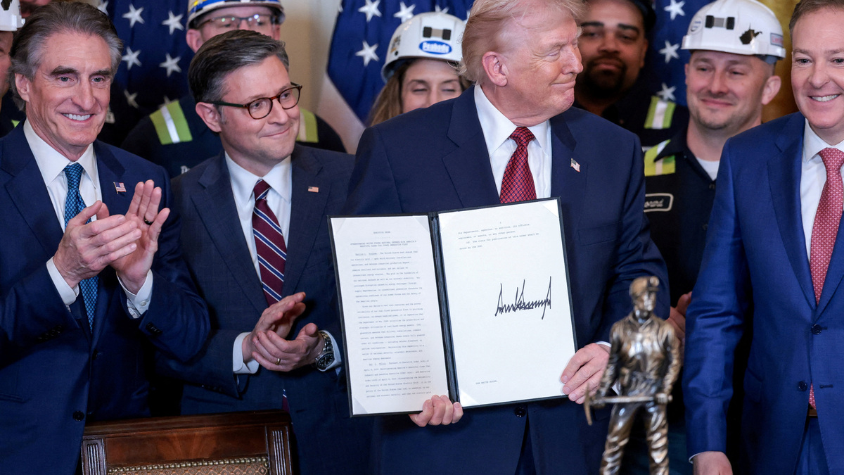 U.S. President Donald Trump holds an executive order titled "Strengthening United States National Defense with America's Beautiful Clean Coal Power Generation Fleet", next to U.S. Secretary of the Interior Doug Burgum, Speaker of the House of Representatives Mike Johnson (R-LA) and Environmental Protection Agency (EPA) Administrator Lee Zeldin, as a statue labelled "Undisputed Champion of Beautiful Clean Coal" the president received from the the Washington Coal Club stands on the table, during an event promoting coal-powered energy sources, in the East Room at the White House in Washington, D.C., U.S. February 11, 2026. REUTERS/Jonathan Ernst REFILE - ADDING ID