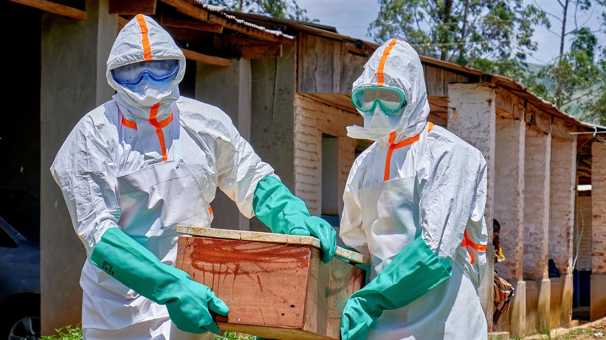Red Cross workers wearing personal protective equipment (PPE) carry a coffin with the dead body of a child who died of Ebola, as aid agencies intensify efforts to contain a new Ebola outbreak involving the Bundibugyo strain in Mongbwalu, Djugu Territory, Ituri province, Democratic Republic of Congo, May 24, 2026. REUTERS/Gradel Muyisa Mumbere/File Photo