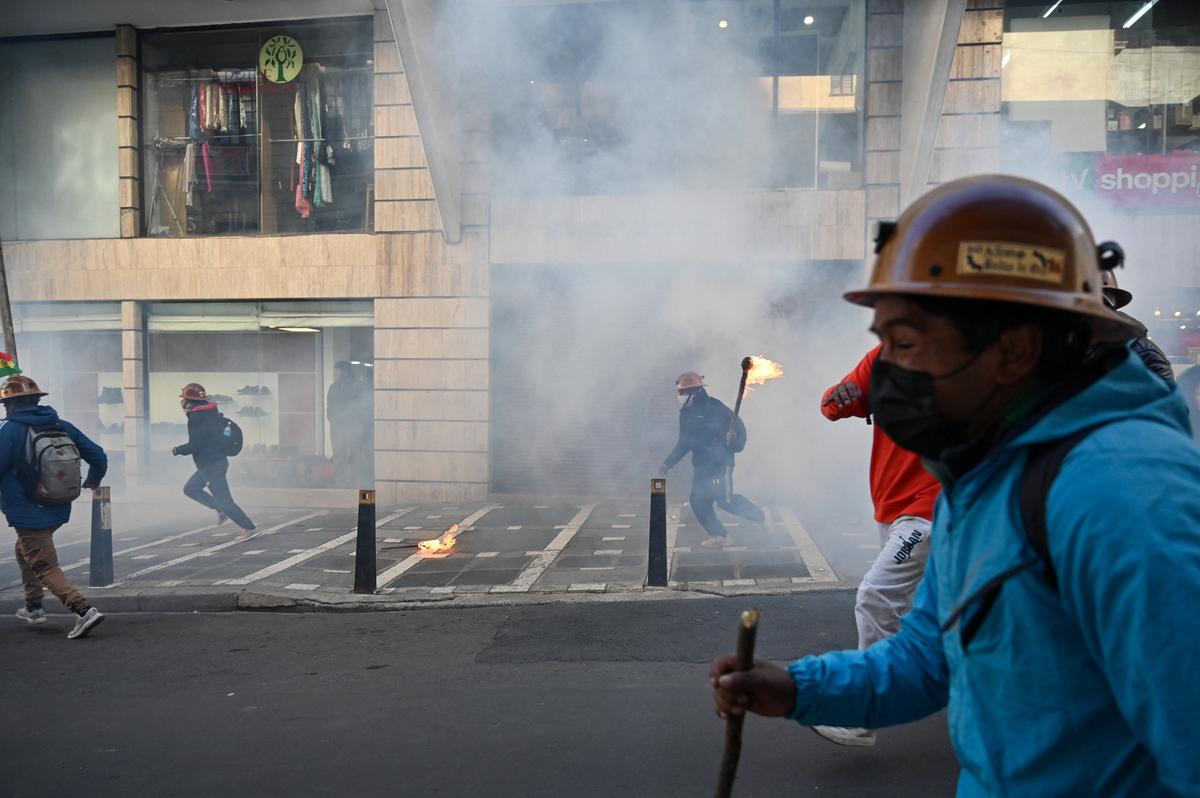 Demonstrators from mining unions react to tear gas fired by police forces as they protest against President Rodrigo Paz's government amid an ongoing economic and fuel crisis, in La Paz, Bolivia, May 14, 2026. REUTERS/Claudia Morales