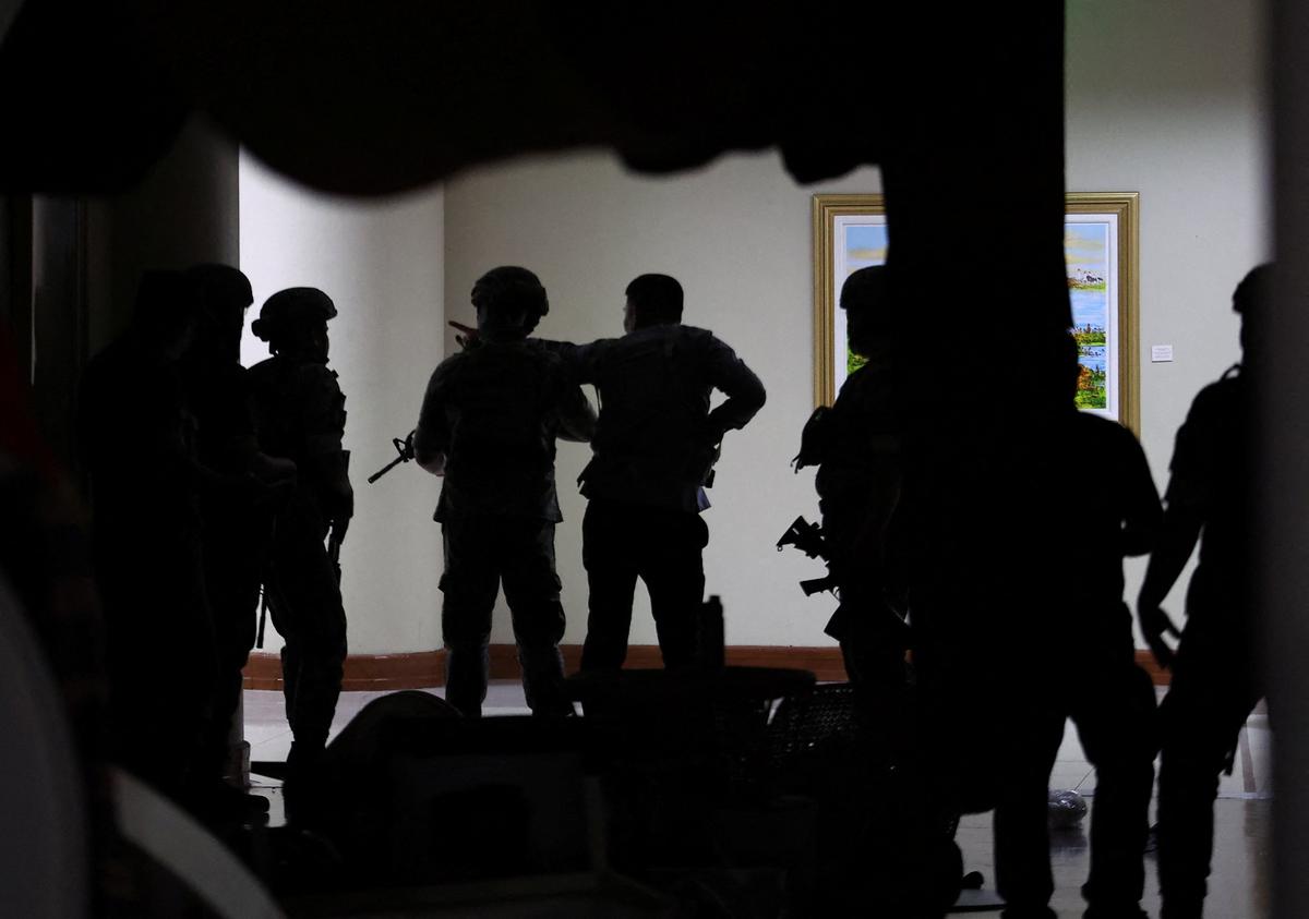 Military personnel in camouflage fatigues enter the Senate building where Philippine Senator Ronald "Bato" dela Rosa, the chief enforcer of former president Rodrigo Duterte's drug war, at the Senate, is under protective custody amid an International Criminal Court warrant, as more than a dozen gunshots were heard at the Philippine Senate on Wednesday, and people were told to run for cover, according to a Reuters witness, in Pasay City, Metro Manila, Philippines, May 13, 2026. REUTERS/Eloisa Lopez